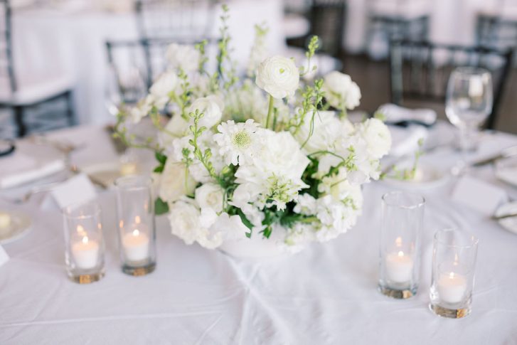 Fall all white reception centerpiece for a round dinner table.